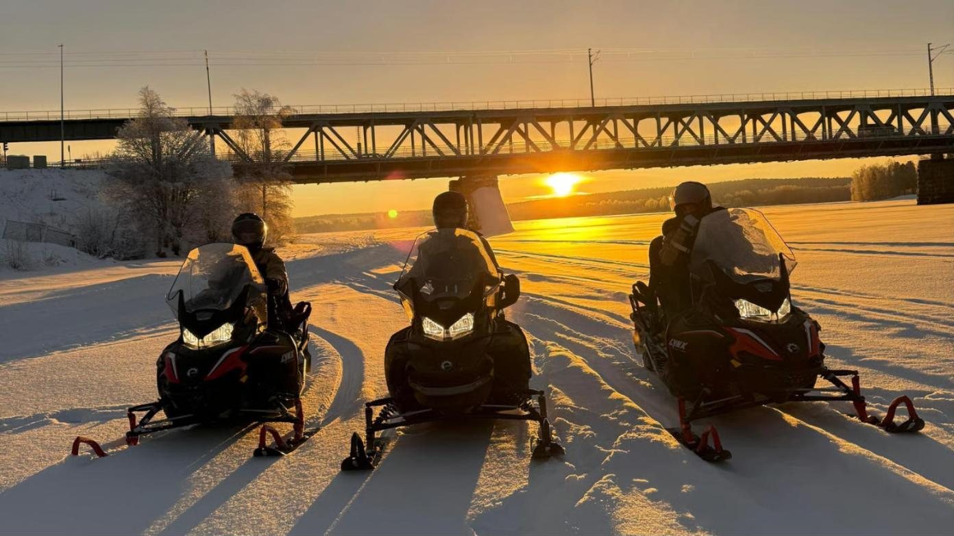 three sleds at sunset, river bridge
